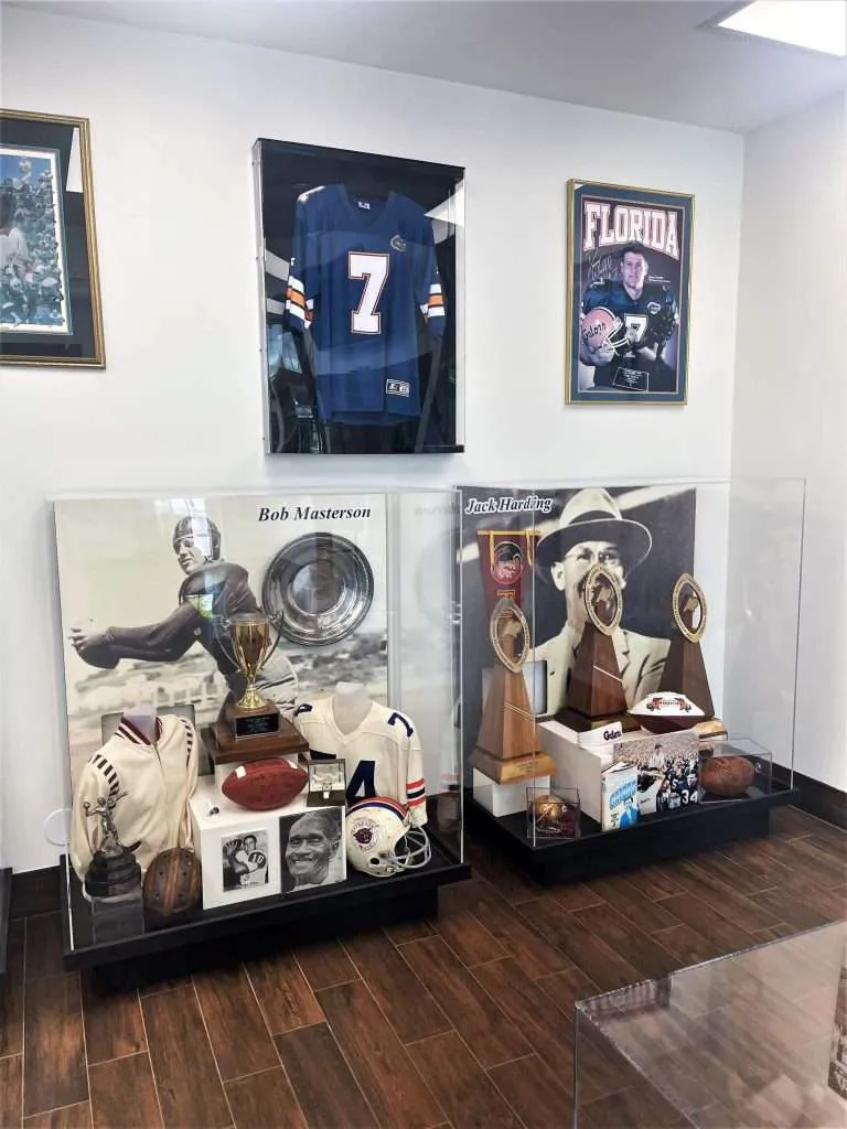 Clear acrylic display cases holding football jerseys, trophies and memorabilia