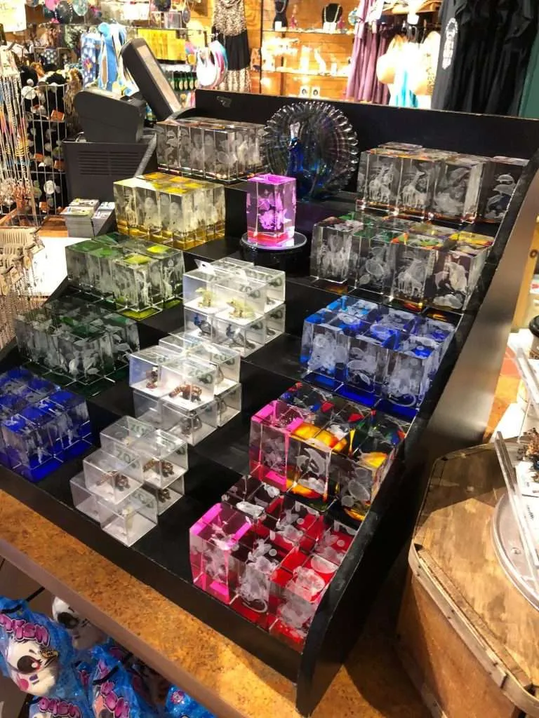 Black acrylic tiered step display holding rows of small 3D laser crystal cubes in a shop