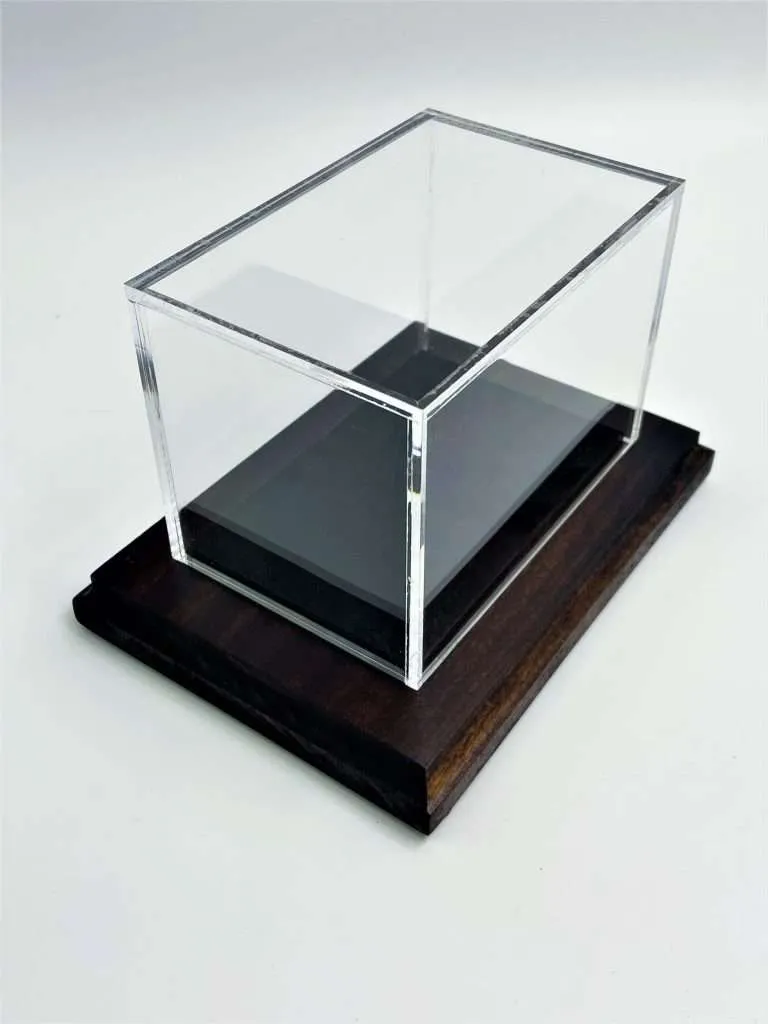 Clear acrylic display case with a black acrylic base seated on a dark wood plinth.