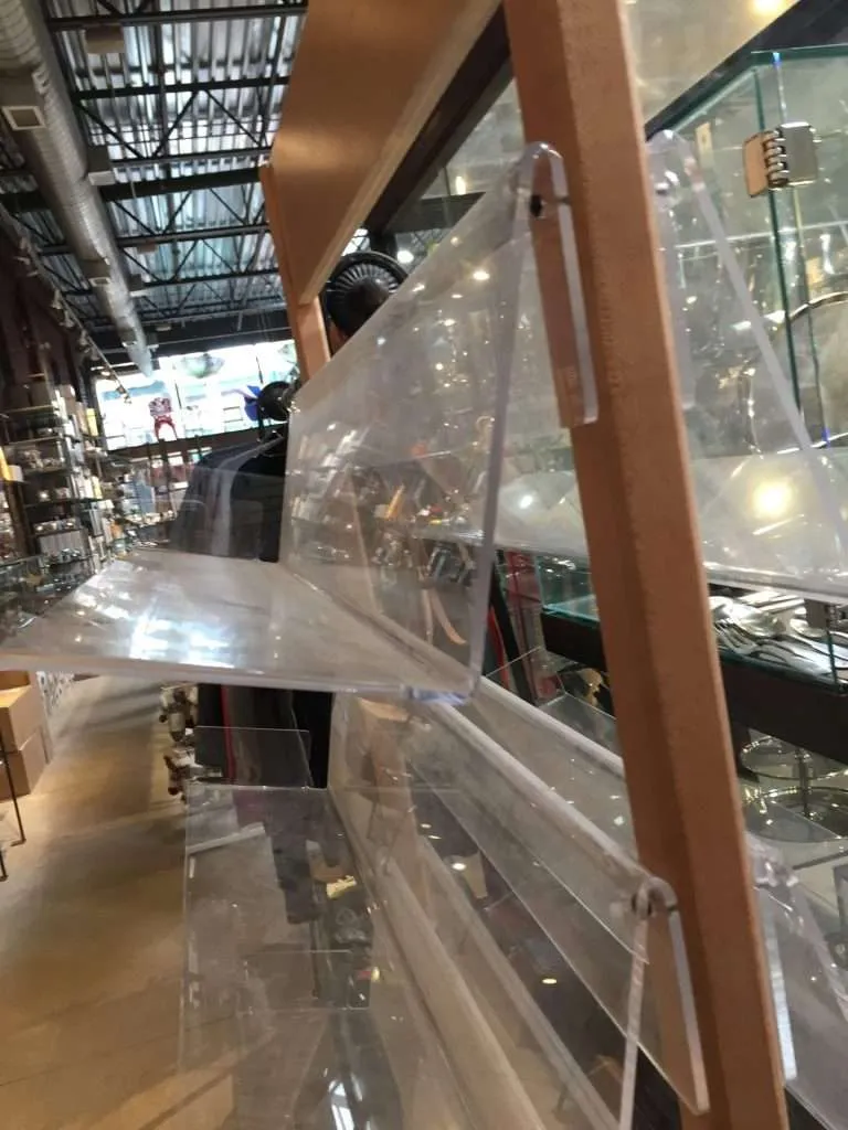 Clear acrylic slanted shelves mounted on a retail display rack.