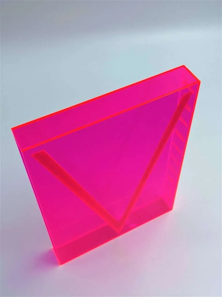 Fluorescent pink acrylic book cover with a custom engraved geometric design