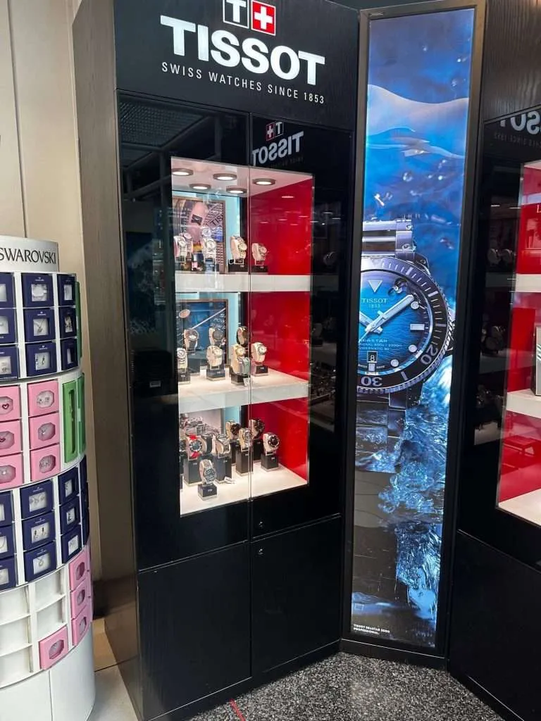 Illuminated retail display case with acrylic shelving for luxury watches.
