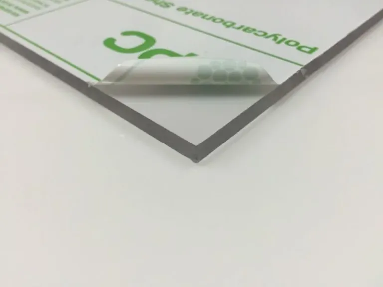 Corner of a clear polycarbonate sheet with printed protective film.