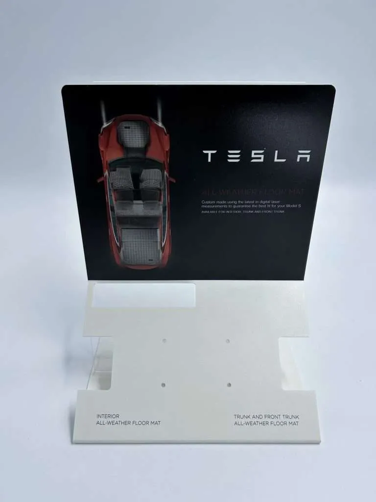 White PVC countertop product display with a full-color printed automotive header graphic