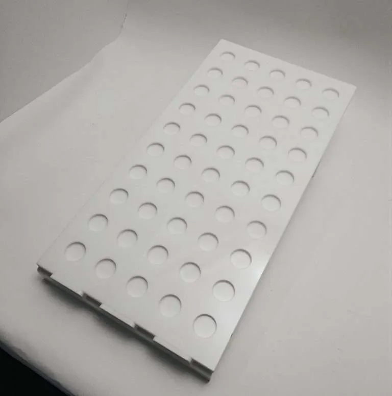 White acrylic tray with CNC-routed circular recesses for holding small items.