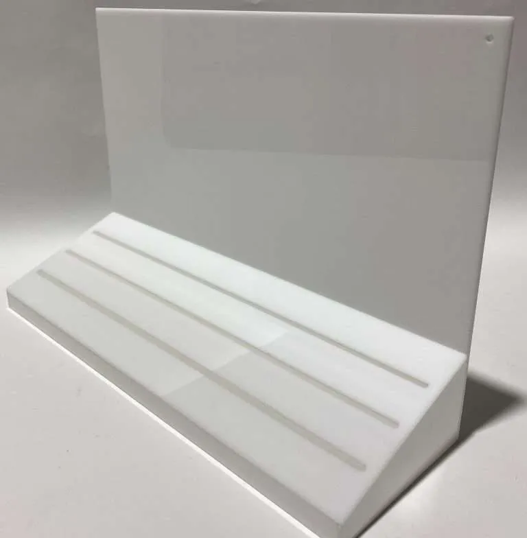 White acrylic countertop display with a tiered stepped base and back panel.